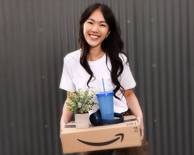 Young person carrying their Prime package with headphones and plant