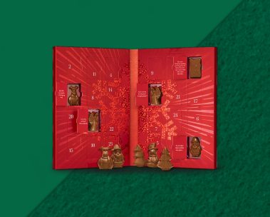 Open Christmas advent calendar with a bright red cover, revealing festive surprises inside.