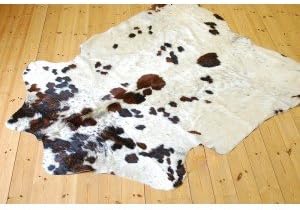 Cowhide Rug. White with small dark brown and black patches. Measures 220 by 180 cm