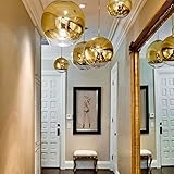 Die s.LUCE Fairy, eine klassische Kugel-Hängeleuchte aus goldfarbenem Metall mit im selben Ton teilverspiegeltem Glas, die bei eingeschaltetem Leuchtmittel tolle Effekte erzeugt.