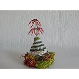 Kleines Perlenbäumchen in rot auf einer Muschel