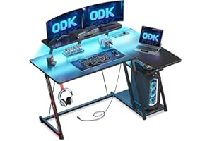 ODK Scrivania Gaming Angolare con Luci LED e Prese di Corrente, 120x70 cm Postazione Gaming con Supporto per Monitor, Scrivania Computer con Ripiano di Stoccaggio Fibra di Carbonio Nera
